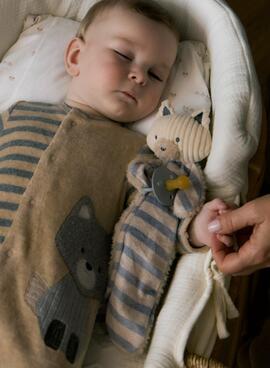 Gugú Mayoral accroche des sucettes à rayures pour bébé.